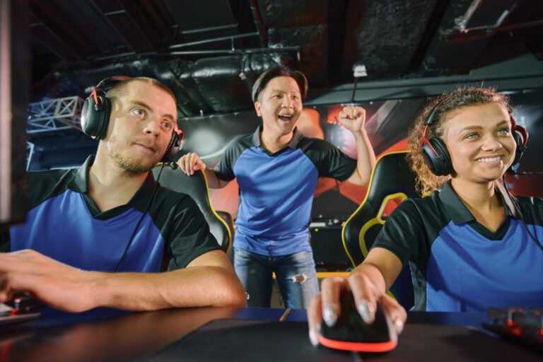 Winning team. Group of happy and excited professional cyber sport gamers celebrating success while playing online video game, they participating in eSports tournament or competition